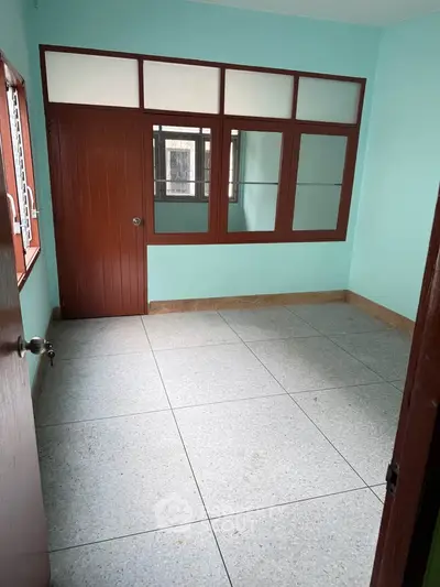 Spacious empty room with large windows and tiled floor, perfect for customization.