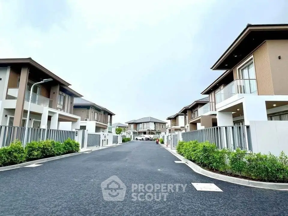 Modern residential street with contemporary houses and lush greenery.