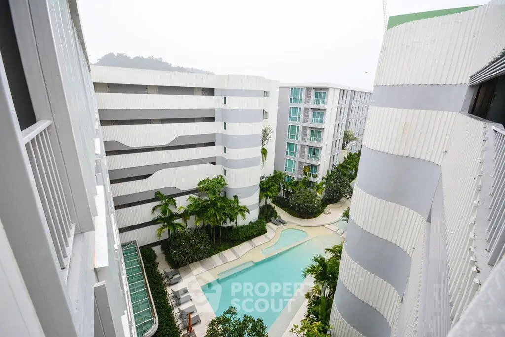 Modern apartment complex with pool and lush greenery, offering a serene urban living experience.