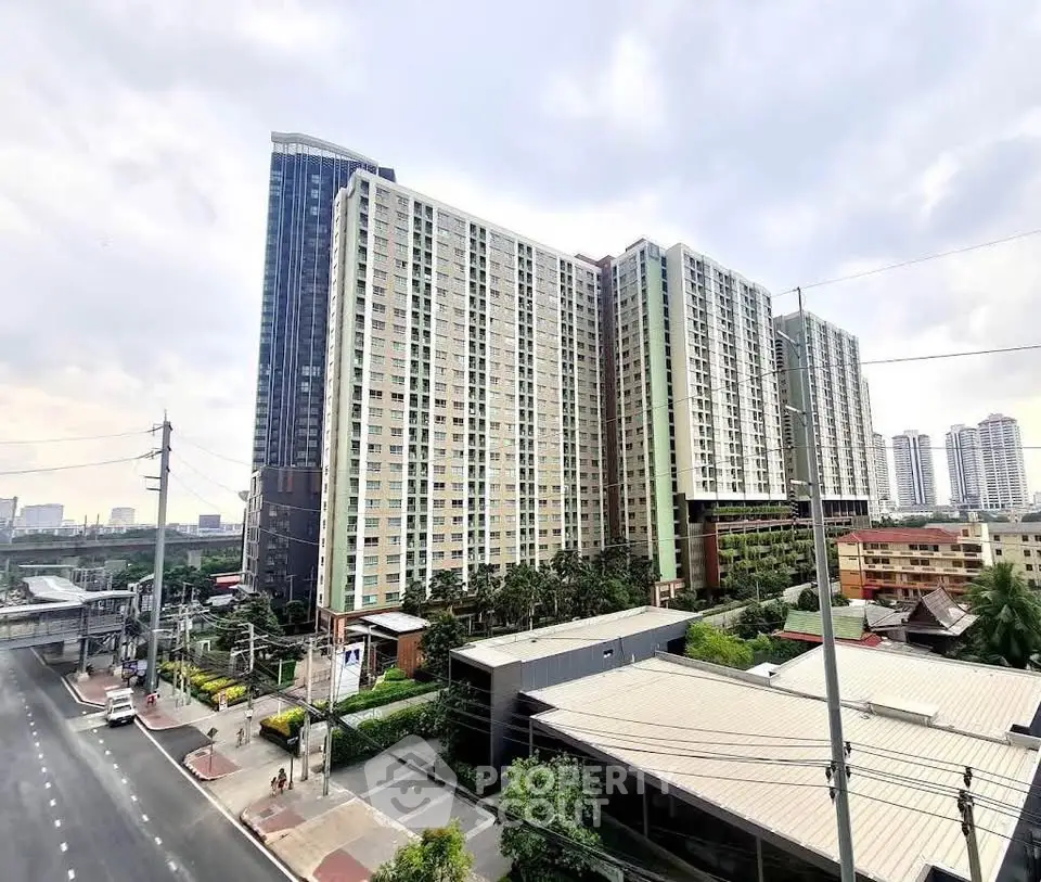Modern high-rise condominium with cityscape view and lush greenery