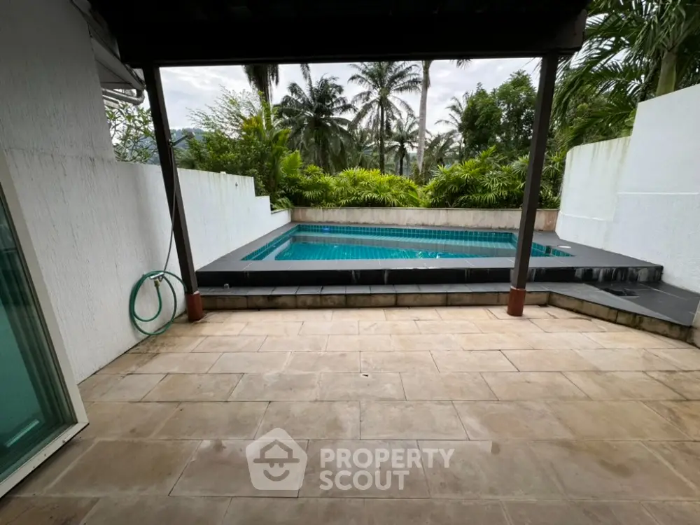 Stunning private pool area with lush greenery and spacious patio, perfect for relaxation and entertainment.