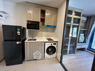 Modern kitchen with sleek appliances and stylish cabinetry in a contemporary apartment.