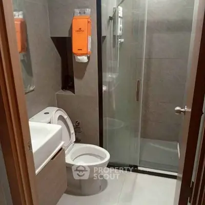 Modern bathroom with sleek design and glass shower enclosure in a contemporary apartment.