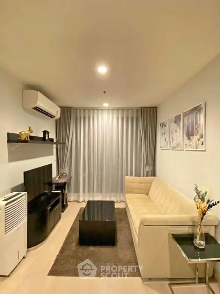 Modern living room with elegant decor, featuring a beige sofa, wall-mounted TV, and stylish shelving.