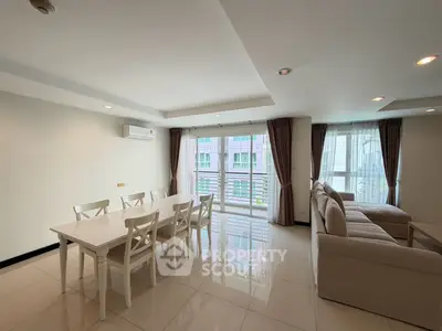 Spacious living room with elegant dining area and large windows in modern apartment