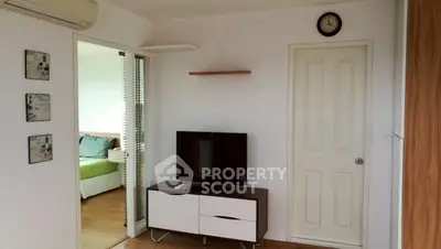 Modern living room with TV and view into cozy bedroom