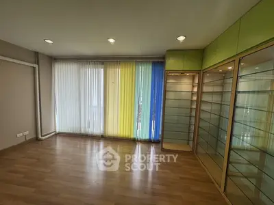 Spacious room with colorful vertical blinds and built-in glass shelves, perfect for modern living.