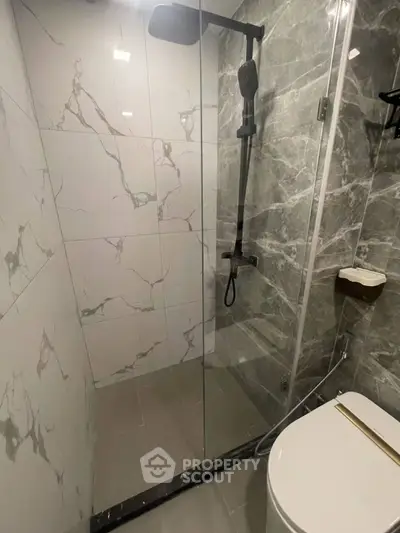 Modern bathroom with marble tiles and glass shower enclosure