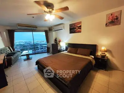 Spacious bedroom with city view, featuring modern decor and large windows for natural light.