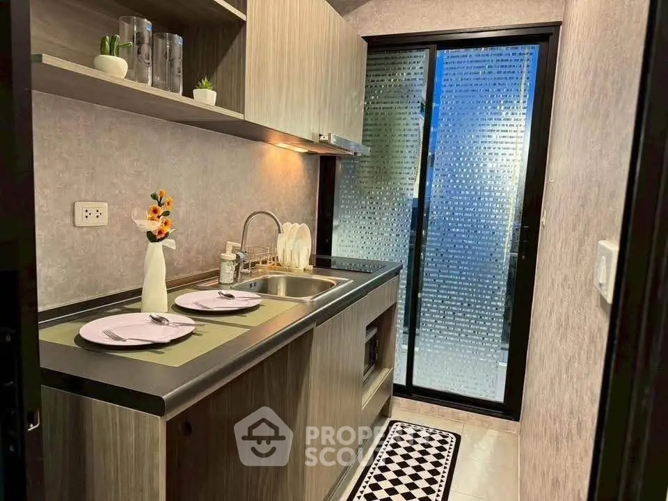 Modern kitchen with sleek cabinetry and frosted glass door, perfect for urban living.