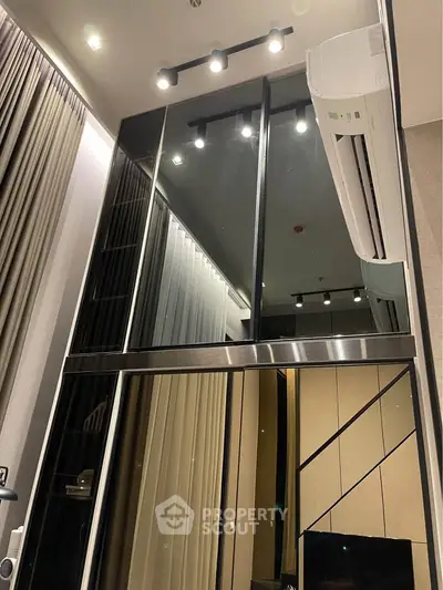Modern high-ceiling interior with sleek glass panels and air conditioning unit