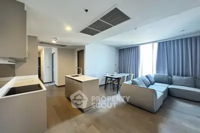 Modern open-layout living room with sleek kitchen and cozy seating area