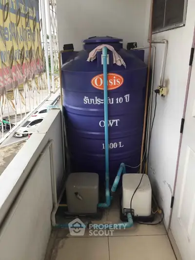 Outdoor water tank system on a balcony with plumbing setup