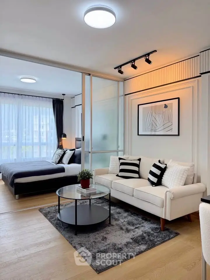 Modern open-plan living room with stylish decor and cozy bedroom view