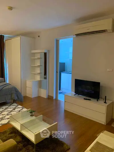 Modern living room with sleek furniture and open layout, featuring a cozy bedroom area and stylish decor.