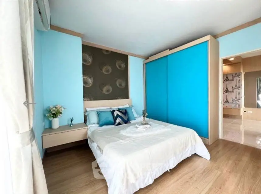 Modern bedroom with blue accents and wooden flooring, featuring a stylish sliding wardrobe.