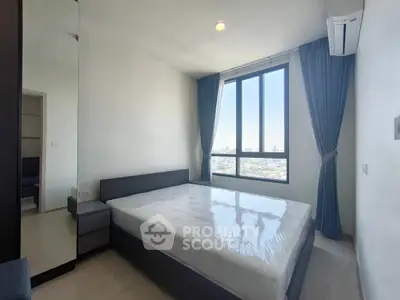 Modern bedroom with large window and city view, featuring a sleek bed and air conditioning.
