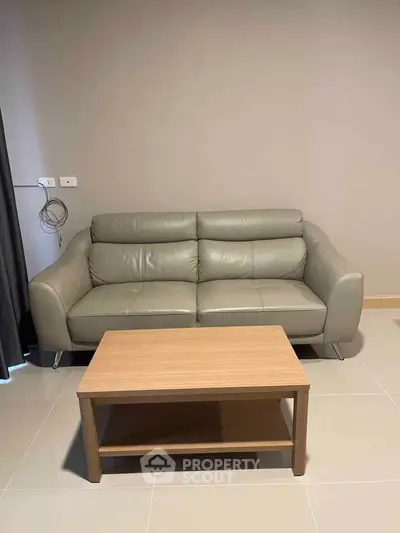 Modern living room with sleek leather sofa and wooden coffee table, perfect for stylish urban living.
