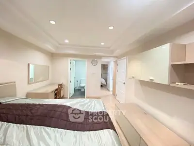 Spacious bedroom with modern decor and ample natural light in a stylish apartment.
