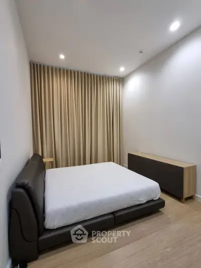 Modern minimalist bedroom with sleek furniture and soft lighting, perfect for a cozy retreat.