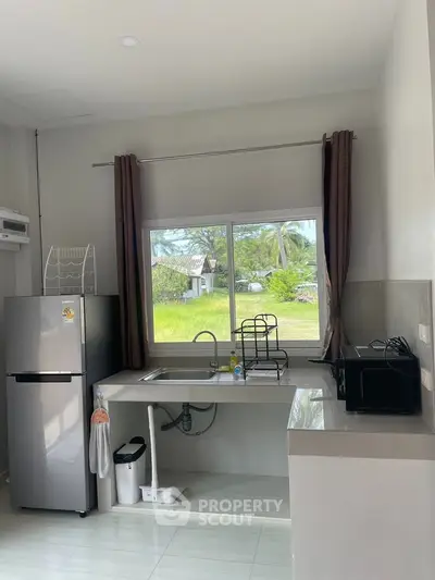Modern kitchen with large window and stainless steel appliances