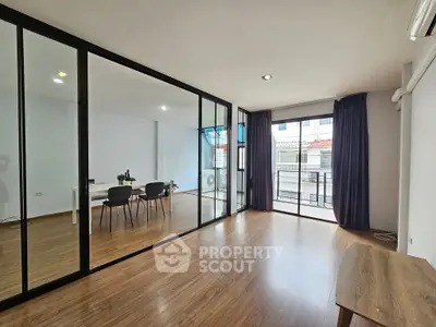 Spacious modern living room with glass partition and balcony access