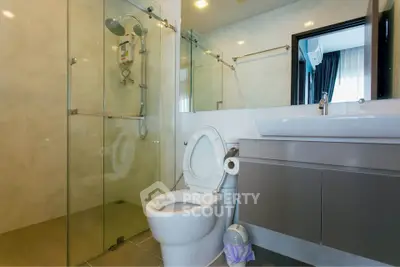 Modern bathroom with glass shower and sleek vanity in luxury home.