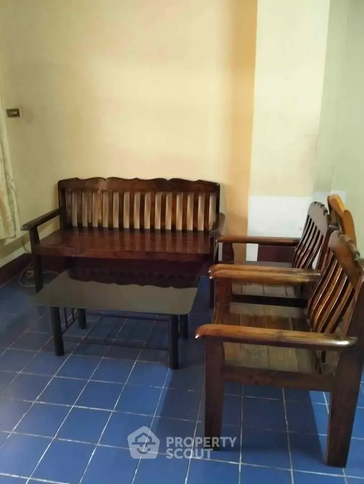 Charming wooden furniture set in cozy living area with blue tiled floor.