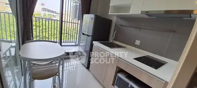 Modern kitchen with sleek appliances and balcony view, perfect for urban living.