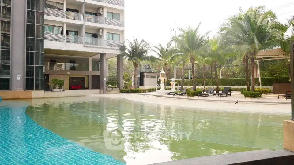 Luxurious apartment complex with serene pool and lush palm trees