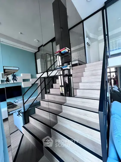 Modern duplex with stylish staircase and open living area, featuring sleek design and contemporary furnishings.