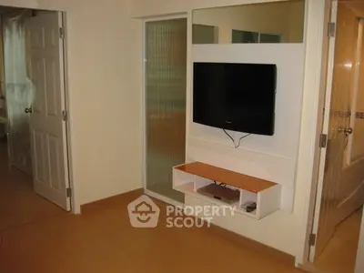 Modern living room with wall-mounted TV and sleek wooden flooring