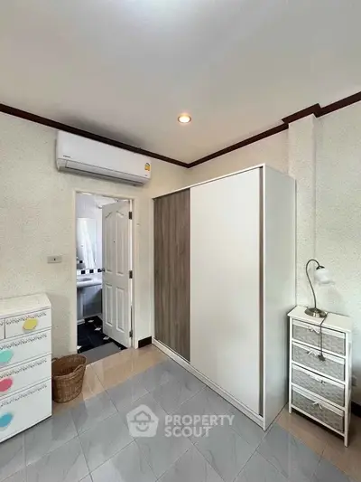 Modern bedroom with sleek wardrobe and air conditioning unit