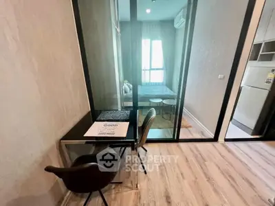 Modern apartment with glass partition, stylish desk, and cozy bedroom view.