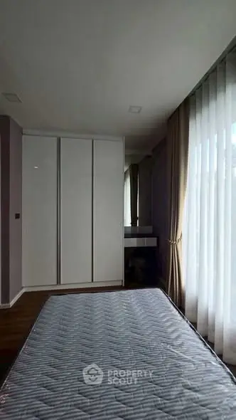 Modern bedroom with large window and sleek wardrobe design