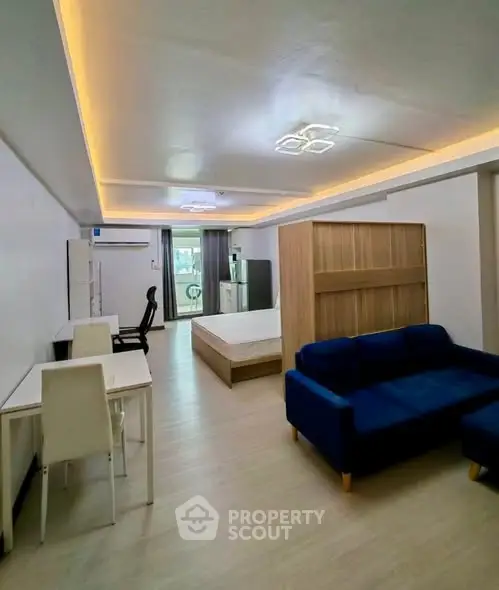 Spacious studio apartment with modern furnishings and ambient lighting