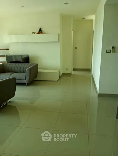 Modern living room with sleek furniture and glossy tiled flooring