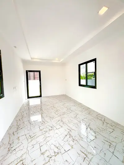 Spacious and bright interior with marble flooring and large windows, perfect for modern living.