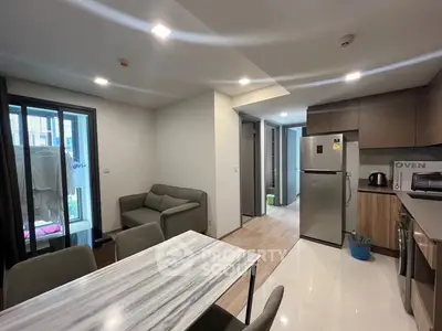 Modern open-layout kitchen and dining area with sleek appliances and cozy seating.
