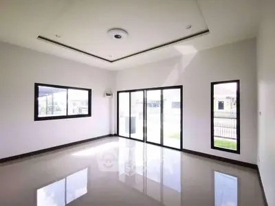 Spacious empty living room with large windows and glossy floor