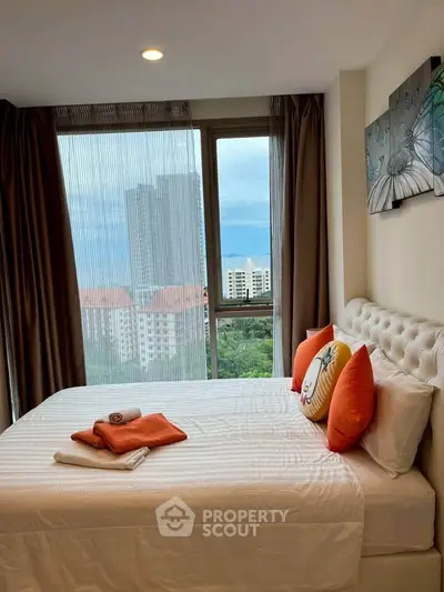 Cozy bedroom with a stunning city view, featuring a plush bed and elegant decor.
