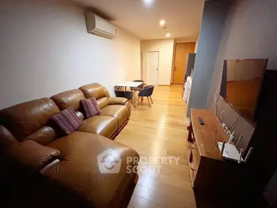 Cozy living room with leather sofa and modern TV setup in stylish apartment.