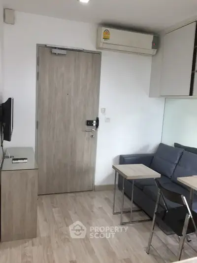 Modern living room with sleek furniture and air conditioning in a compact apartment.