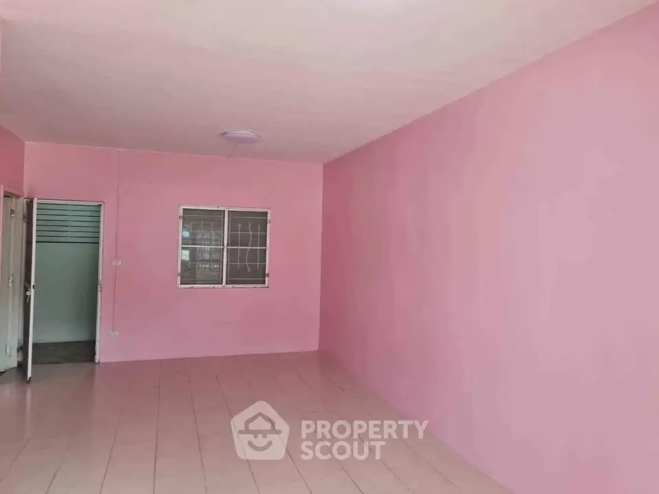 Spacious pink-walled room with tiled flooring, ideal for creative interior design.