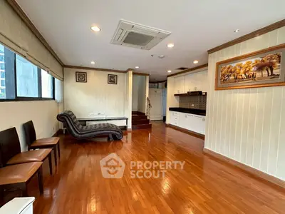 Spacious living room with wooden flooring and elegant decor in modern apartment.