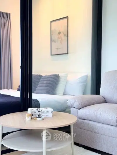 Cozy modern living room with stylish decor and a glimpse of a comfortable bedroom.
