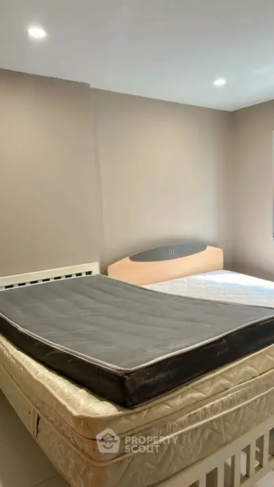 Spacious bedroom with stacked mattresses and neutral wall colors