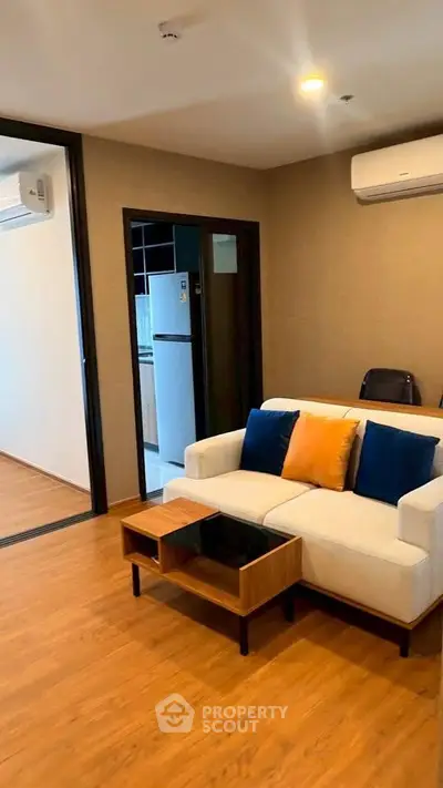 Modern living room with stylish sofa and open kitchen layout in a cozy apartment.