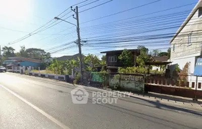 Charming suburban street view with houses and lush greenery, perfect for peaceful living.
