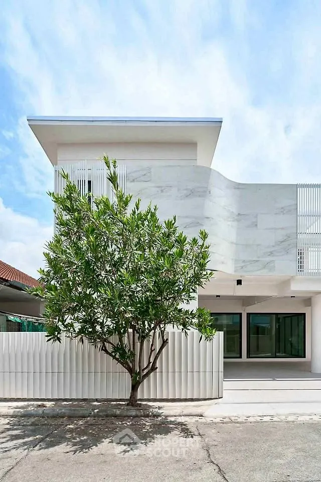 Modern minimalist building exterior with sleek design and lush greenery, perfect for contemporary living.